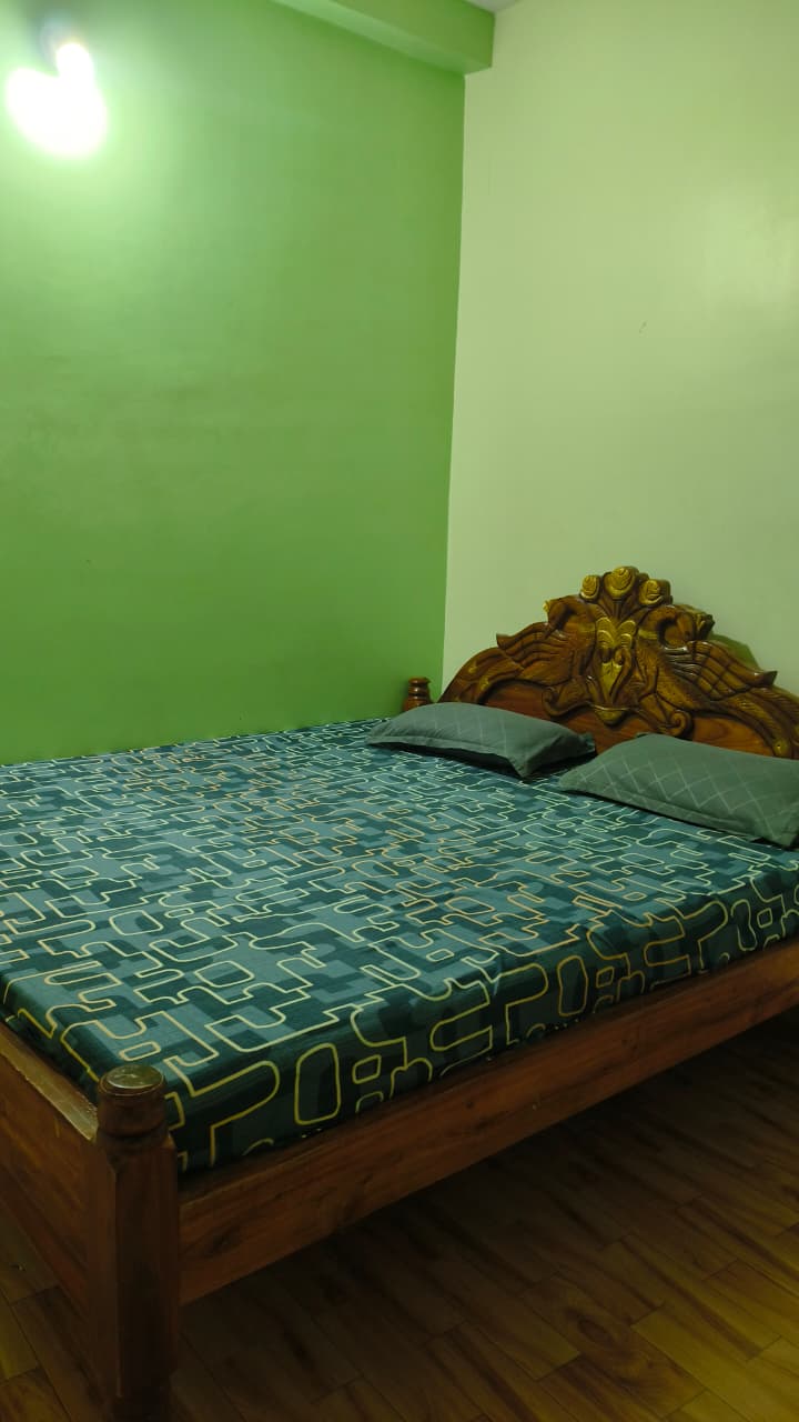 Guest bedroom with wooden bed and pillows, accommodation near Lighthouse in Puri