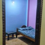 Guest accommodation storage area with open green shelves