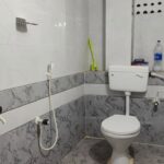 White washbasin and blue-framed mirror on tiled bathroom wall